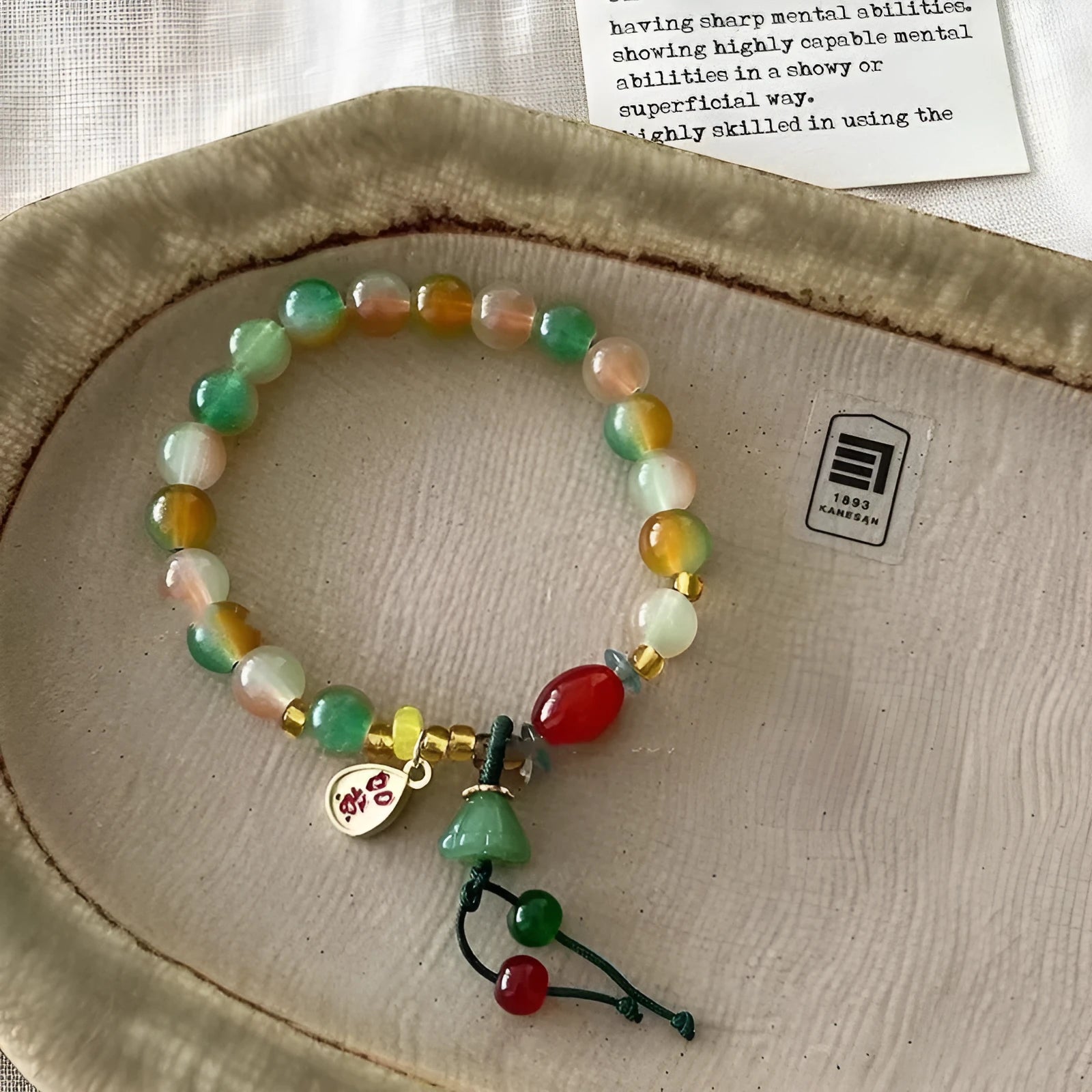 Handmade adjustable bracelet with a detailed lotus charm on a mixed material band.