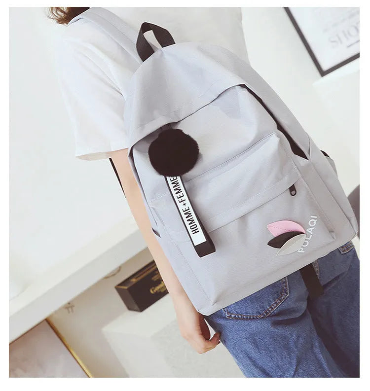 Casual canvas college schoolbag with leaf pattern in green, shown with size and anti-theft features.