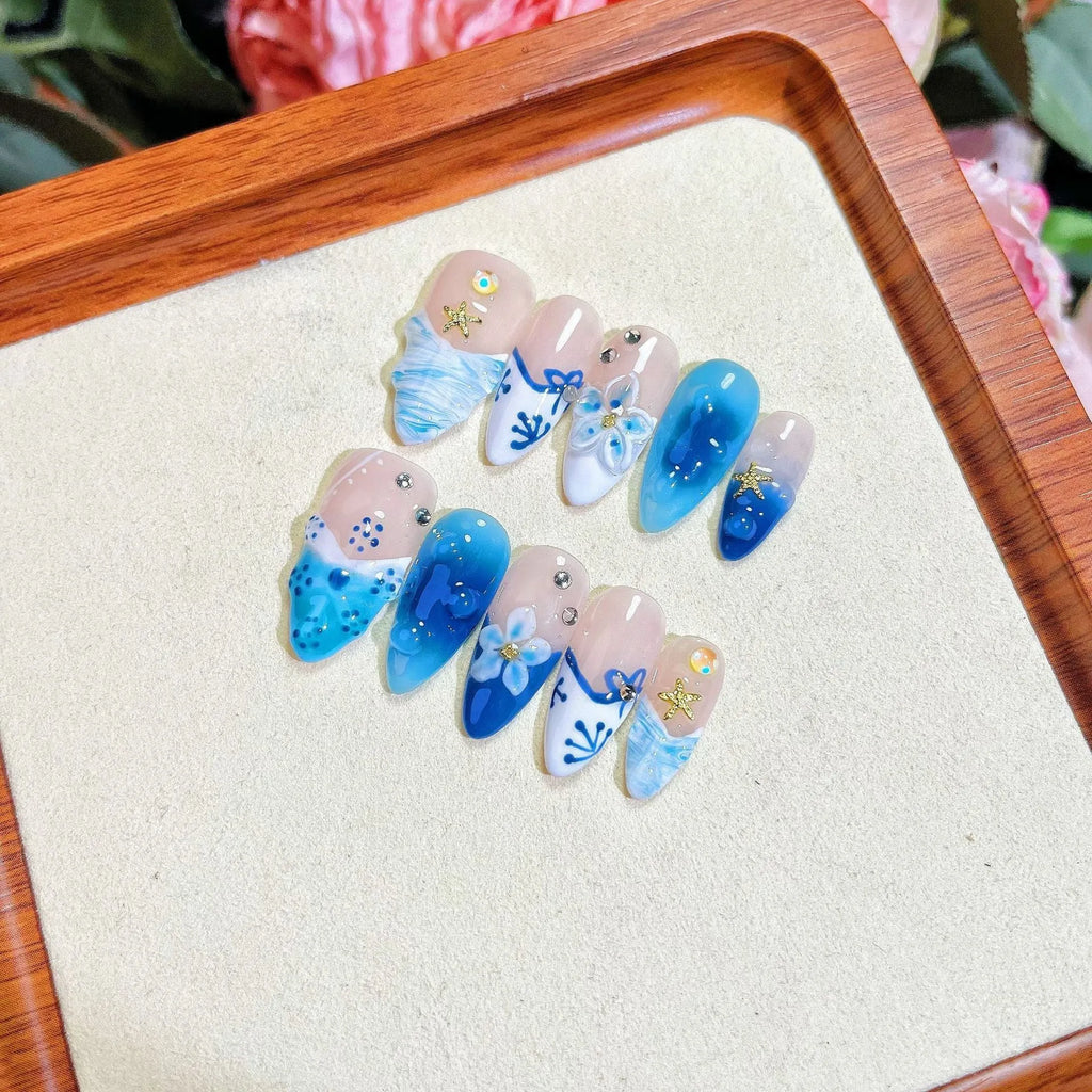 Blue hand-painted carved fake nails with summer ice patterns, transparent sections showing natural nails, four size options displayed