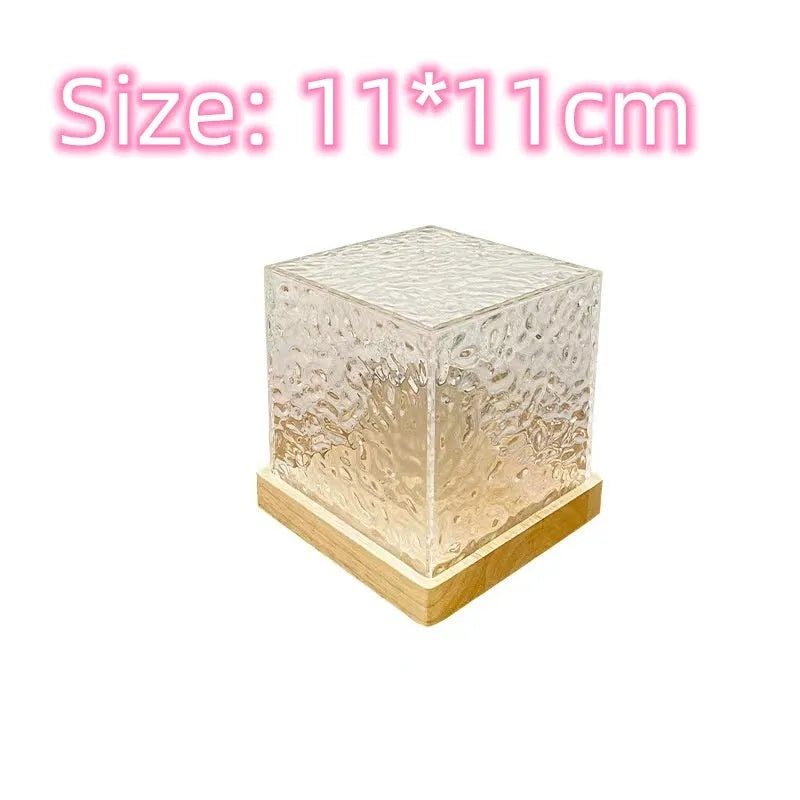 Crystal table lamp projecting blue water ripple light pattern on wall