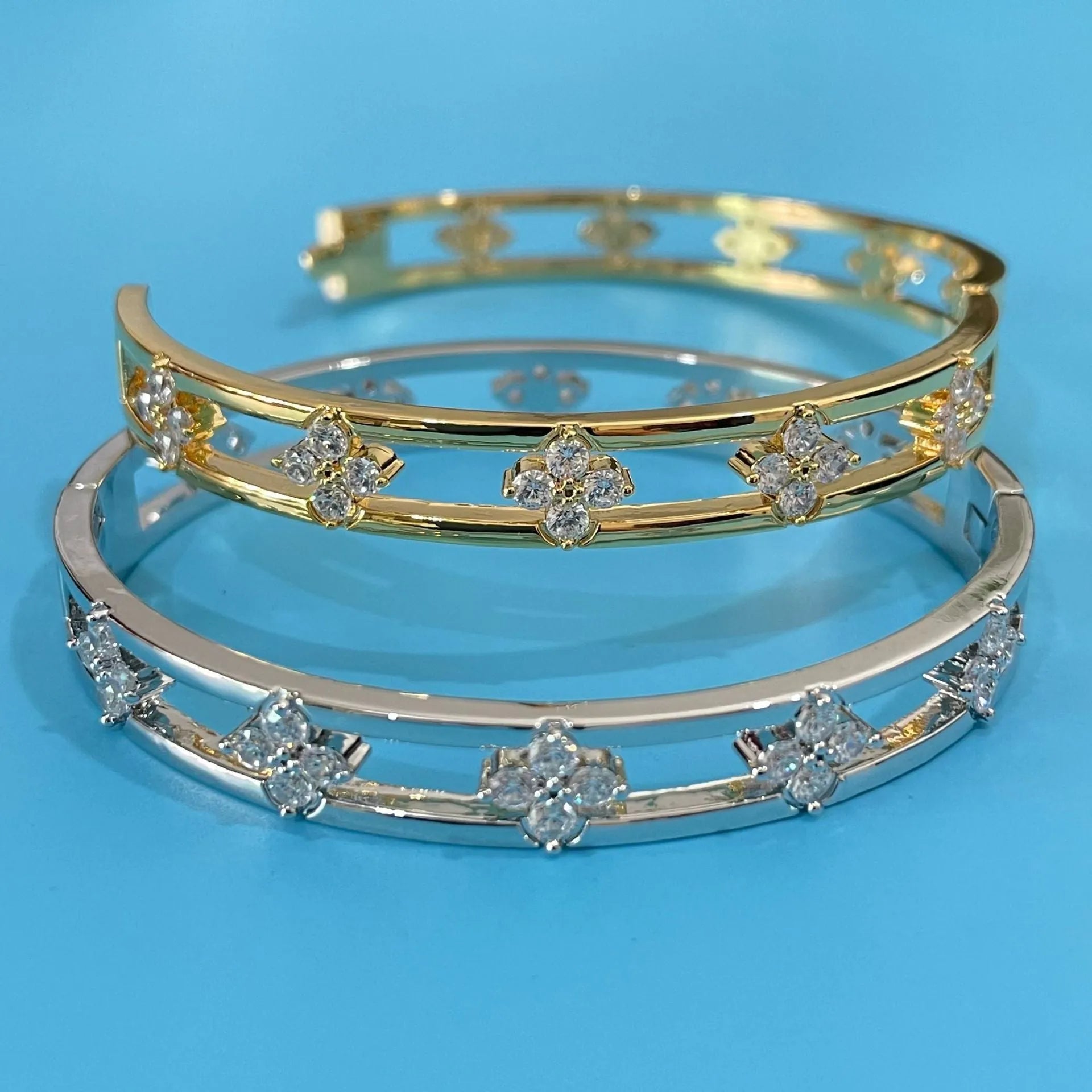 Gold and silver hollow women's bracelets with four-leaf clover charms and inlaid zircon detailing.