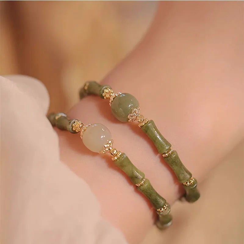 A simple geometric Hetian jade bracelet for women with a Yuan dynasty smoked design, shown in dark green.
