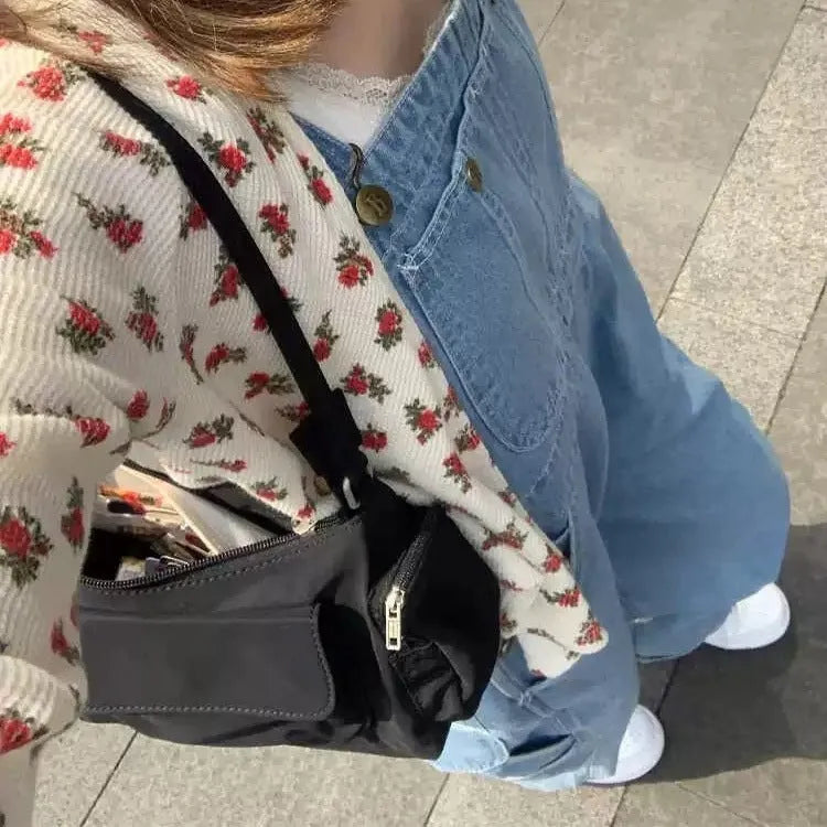 Black shoulder bag with two pockets showing side line detailing, measuring 24cm long by 9cm wide