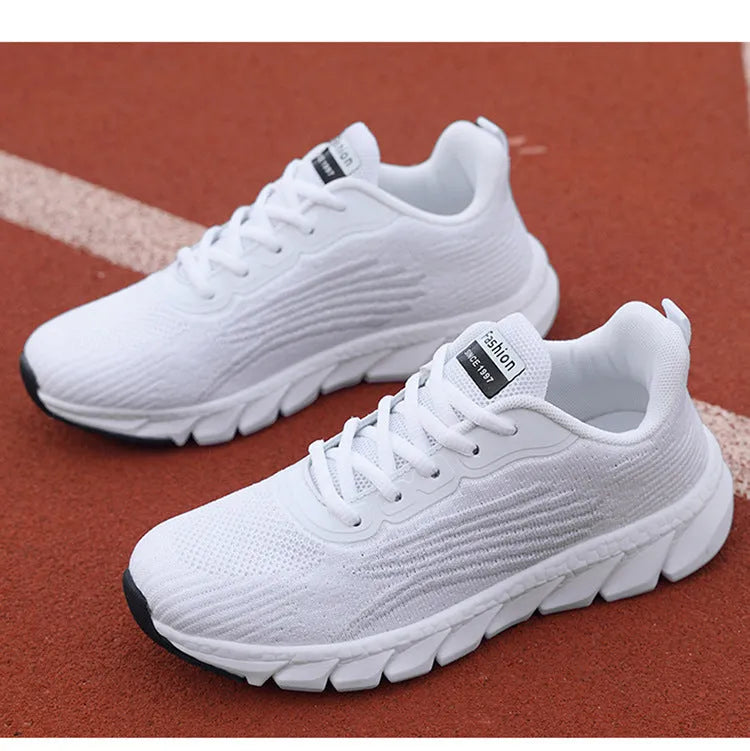 Women's low-cut black and white casual running sneakers with cross-strap detail and a lightweight MD sole.
