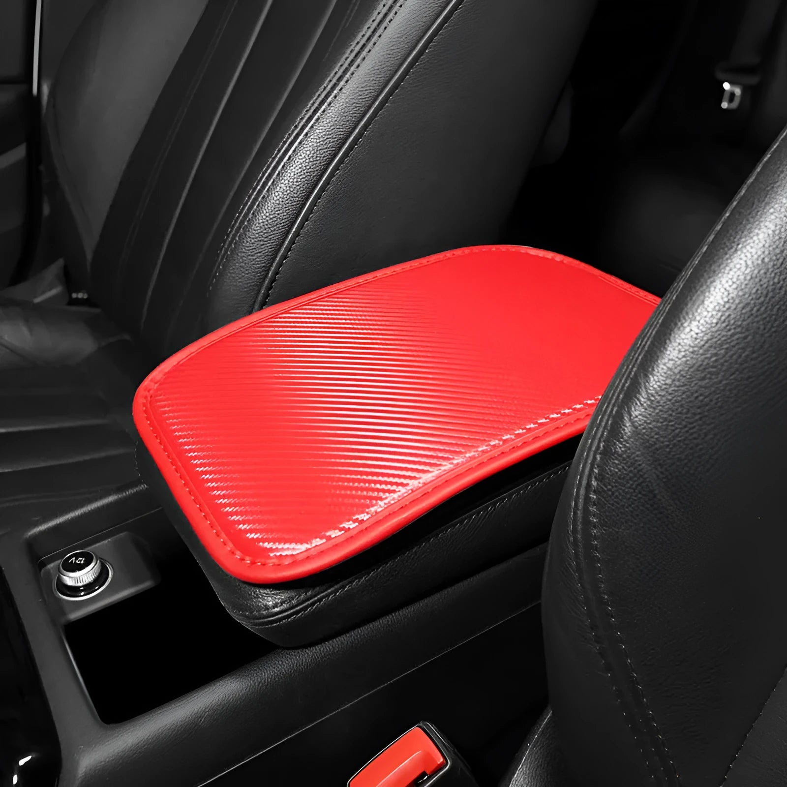 Leather car armrest cushion in black, khaki, red, and white colours, shown on a car centre console.