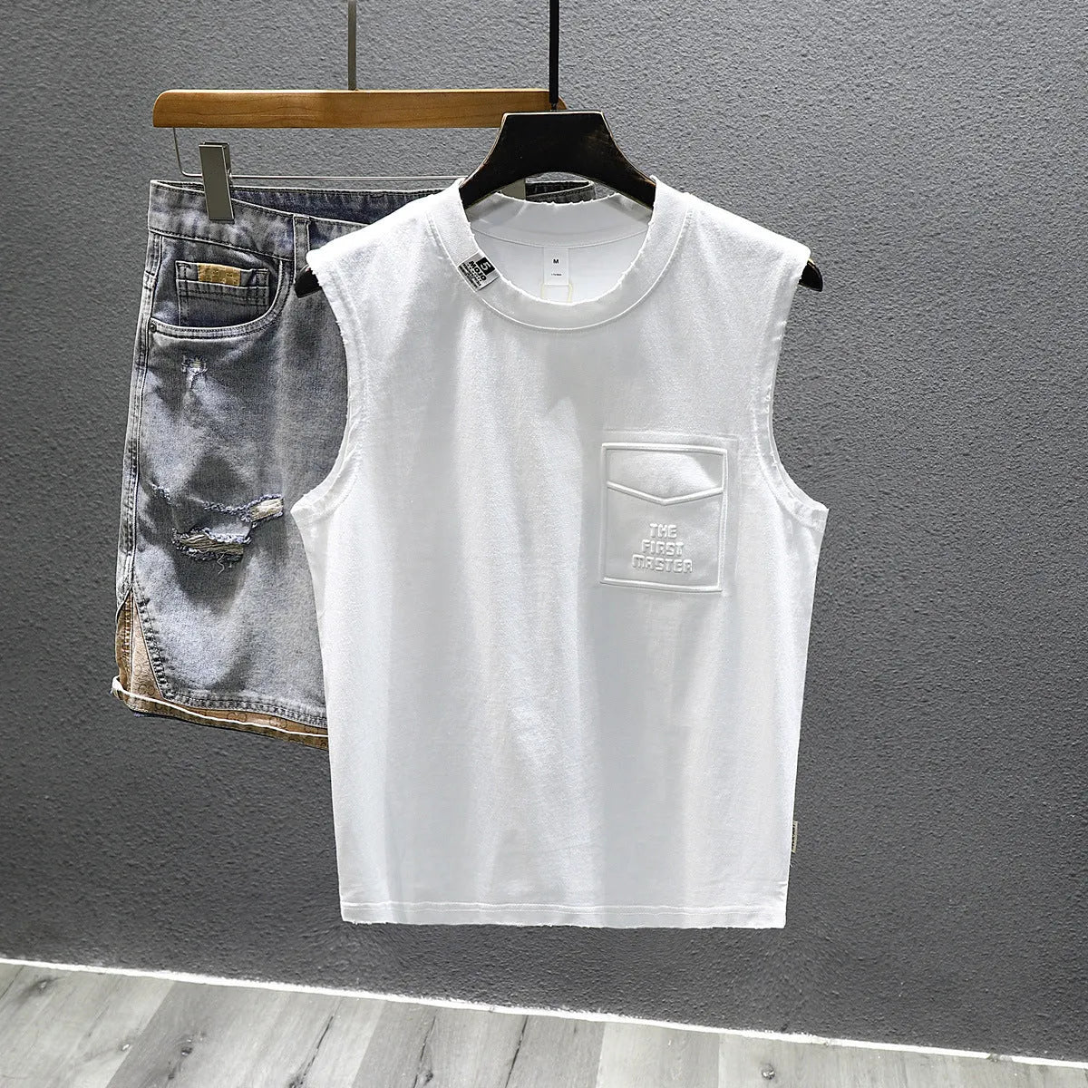 Solid colour loose fit cotton sleeveless t-shirt on a hanger, shown in black and white colour options.