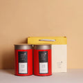 Green metal tin can tea storage box with sealed lid, shown next to loose-leaf tea.