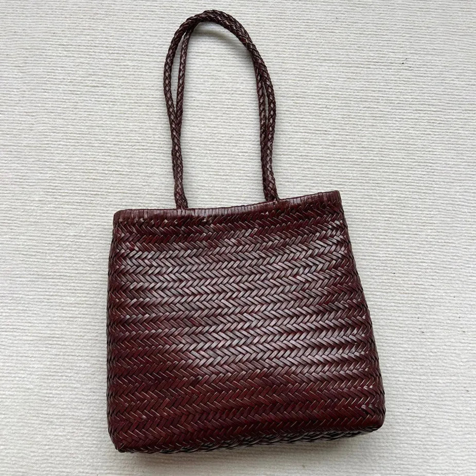 Brown woven leather tote bag with three-dimensional pocket, showing 27x30x6cm dimensions and handmade construction