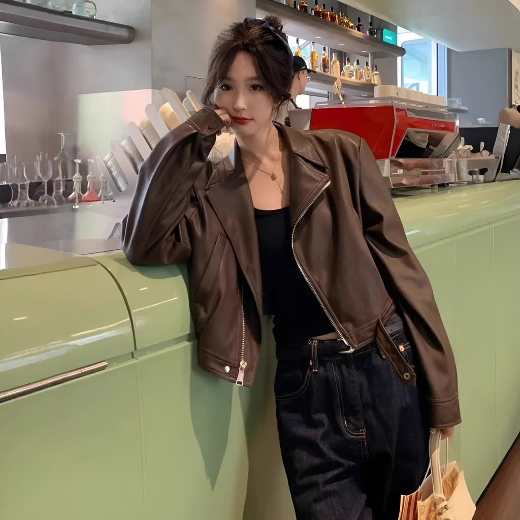 Brown women's retro slim-fit imitation leather jacket with a pocket on a hanger.