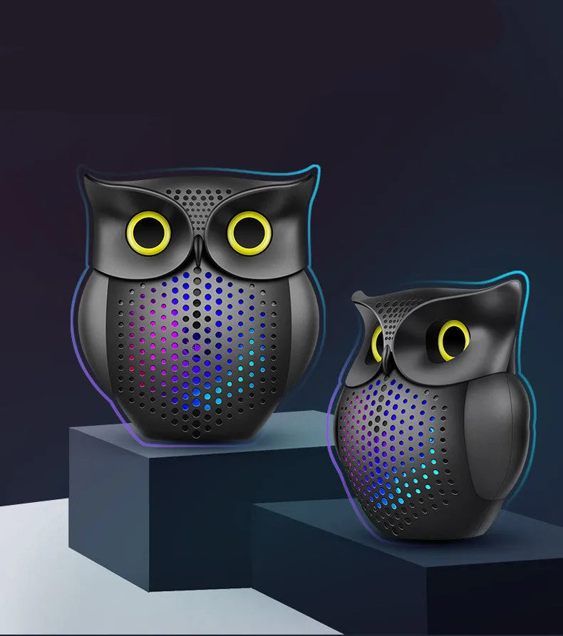 Black plastic owl-shaped portable Bluetooth speaker on a table.