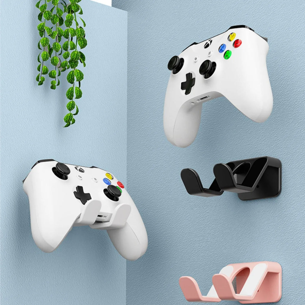 Black wall-mounted gaming controller rack holding two controllers with adhesive mounting system visible