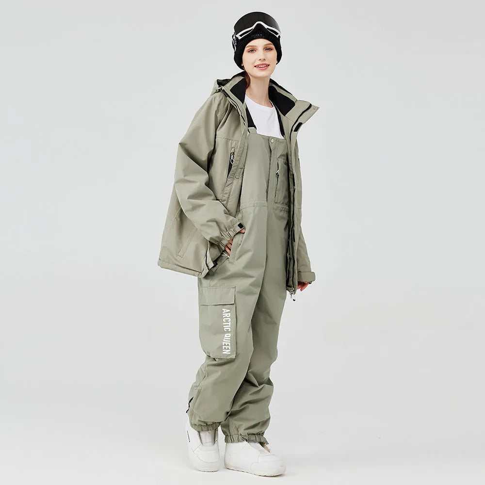Men's and women's winter ski suit in blue top with grey-blue pants, showing waterproof construction for snow sports
