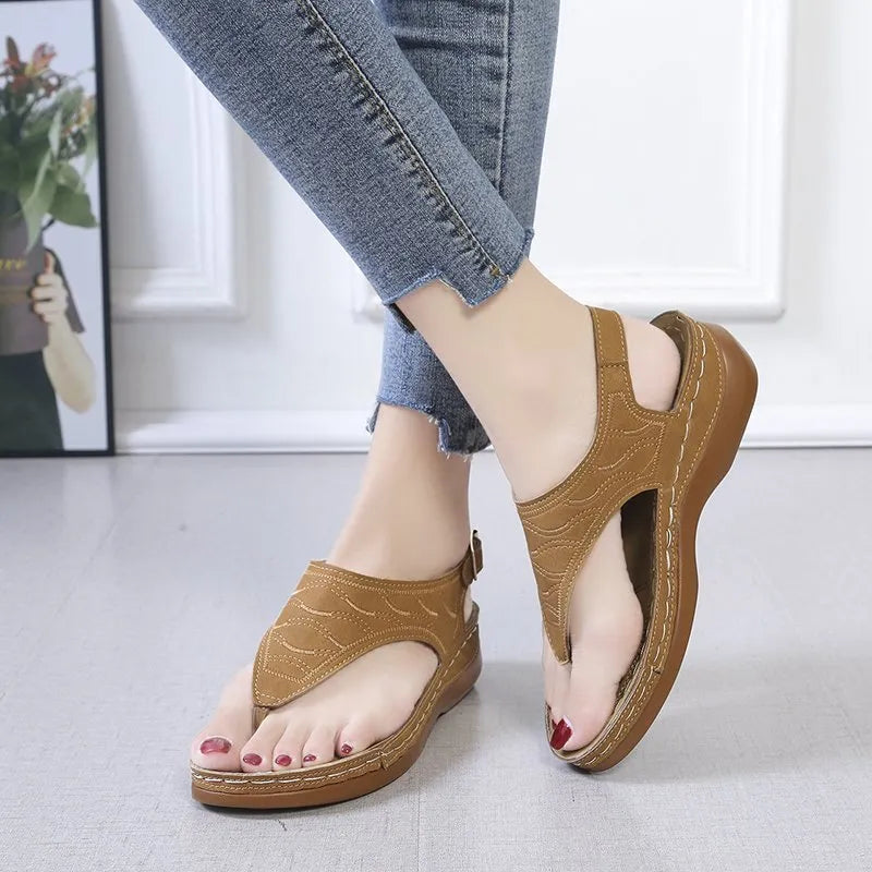 Women's casual wedge heel flip flop sandals with an adjustable buckle strap on the back, shown in a solid colour.