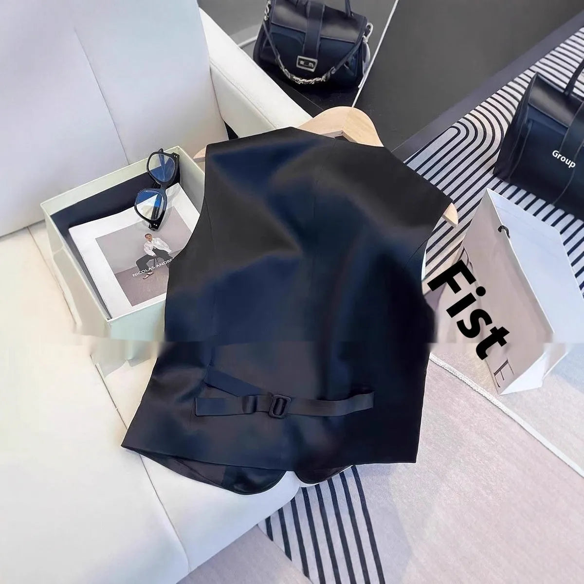 Black satin vest with sleeveless design and splicing details, shown on hanger