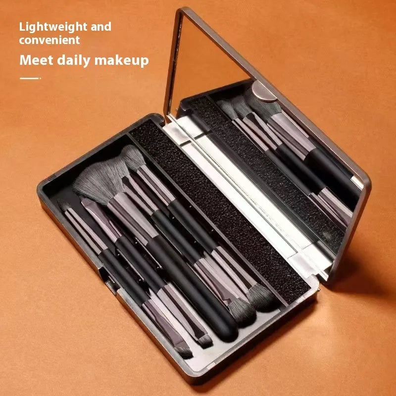 Portable makeup brush set with mirror showing artificial fibre brush heads and silver/gold plastic handles
