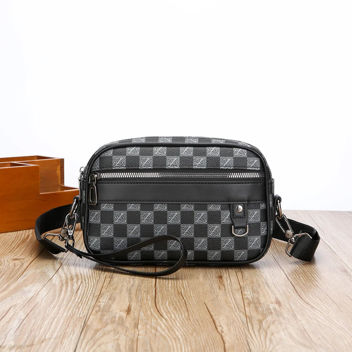 Men's black casual shoulder messenger bag with geometric pattern and handheld strap.