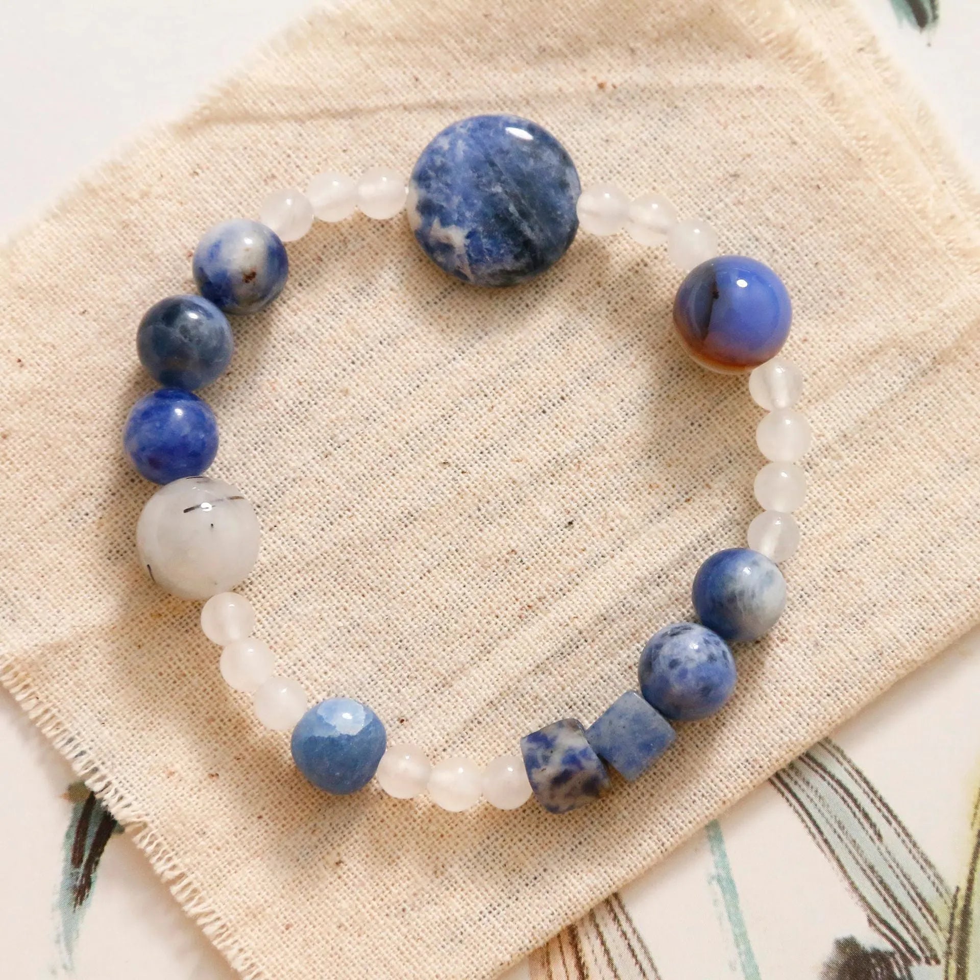 Hand-woven natural stone bracelet with blue point stone and black hair crystal agate in geometric design