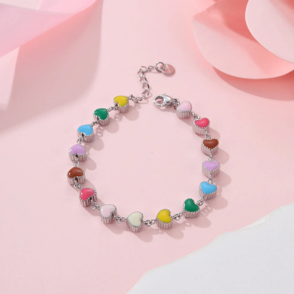 Gold and steel colour heart-shaped titanium steel bracelet on a model's wrist.