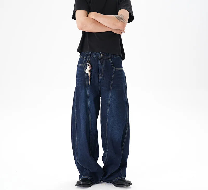 Dark blue wide leg jeans with a distressed wash and machete cut, laid flat.
