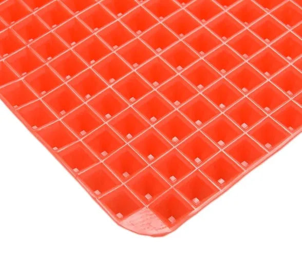 Red silicone pyramid cooking mat with grid pattern for oven and BBQ use