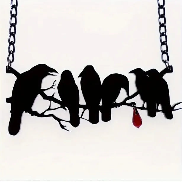 Black crow pendant necklace with cross chain on dark background