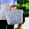 Light blue canvas shoulder bag with bronzing flower pattern and double adjustable straps