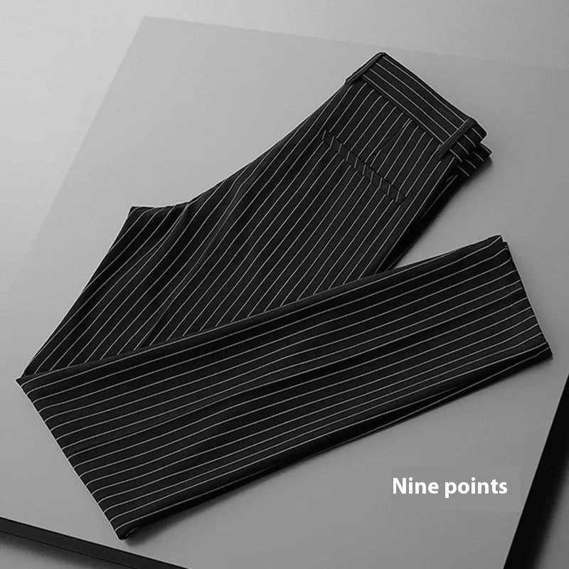 Man wearing loose fit thin striped suit pants in a crop jeans style, available in black or white.