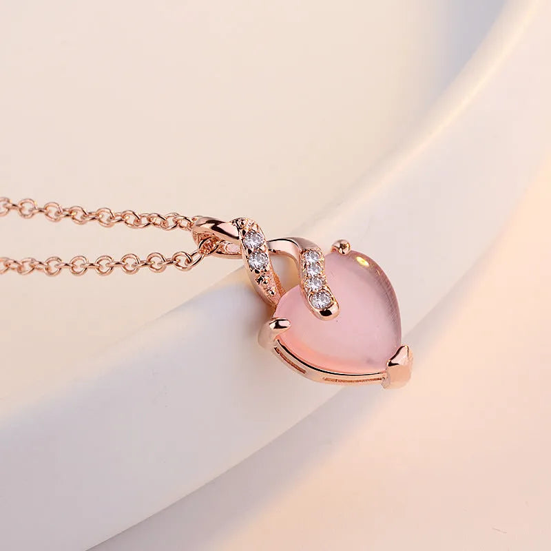 Women's heart-shaped pink crystal pendant necklace on rose gold cross chain
