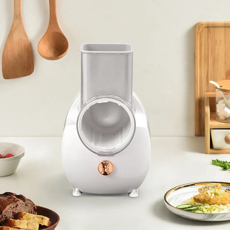 White electric vegetable slicer with rotary grater mechanism and suction base on kitchen counter