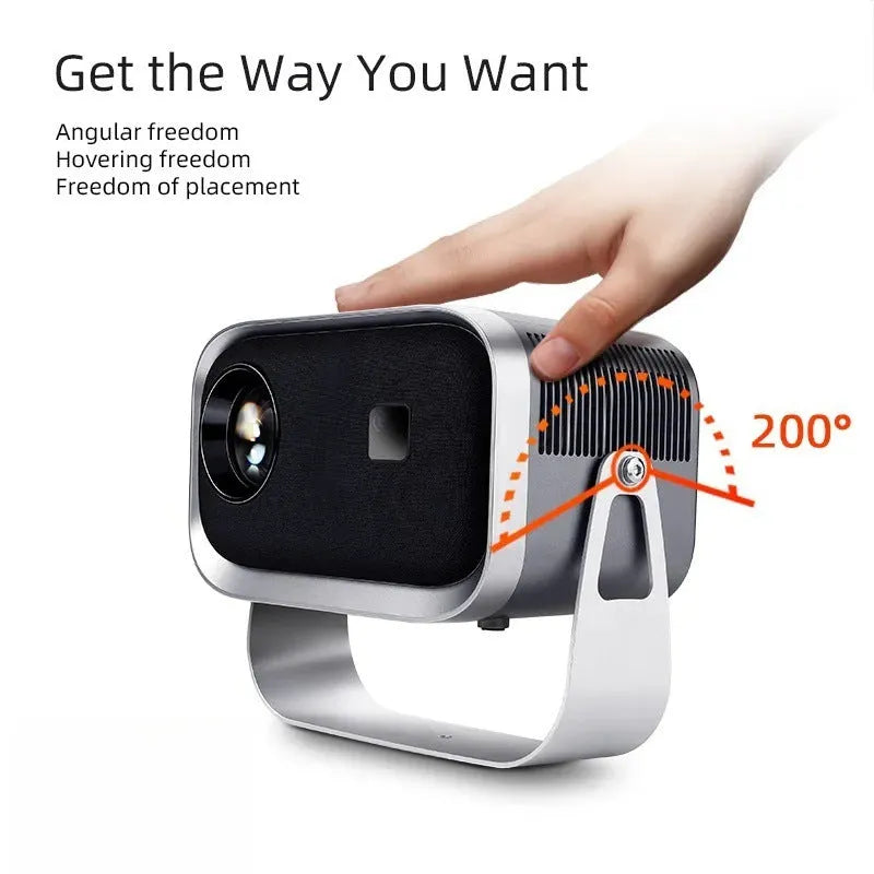 Portable Android 4K Full HD home projector with mobile phone on a table.
