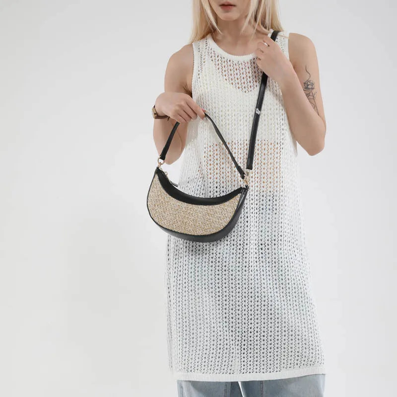 Hard straw women's crossbody dumpling bag in black with contrast stitching and internal organisation pockets.