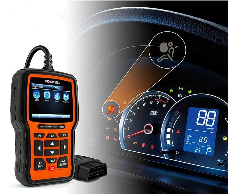 Foxwell NT510 orange and black automotive diagnostic tool with data cable on a workshop bench