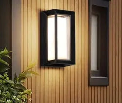 IP65 waterproof outdoor wall lamp with acrylic shade and aluminium body, shown in a garden setting.