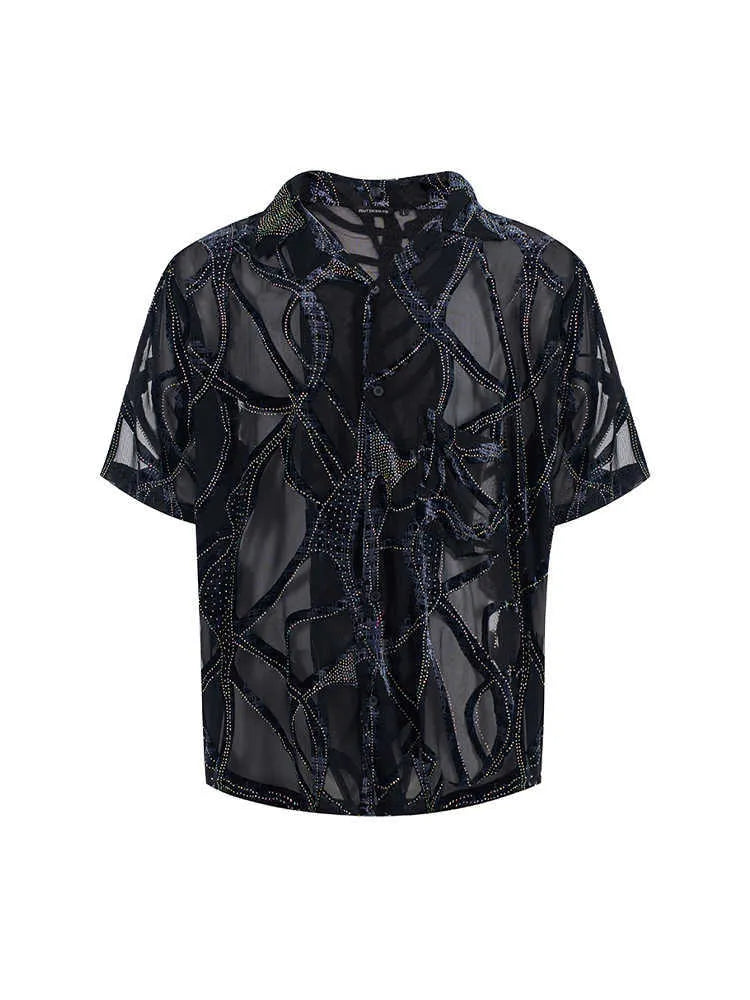 Man wearing a black translucent short-sleeved shirt with a snake pattern, featuring a lapel collar and loose fit.
