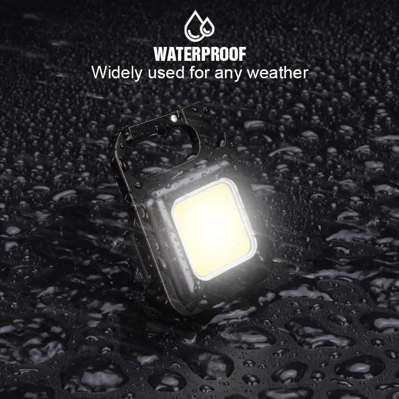 Black aluminium alloy keychain light with magnetic base and foldable handle, measuring 6 cm by 4.2 cm