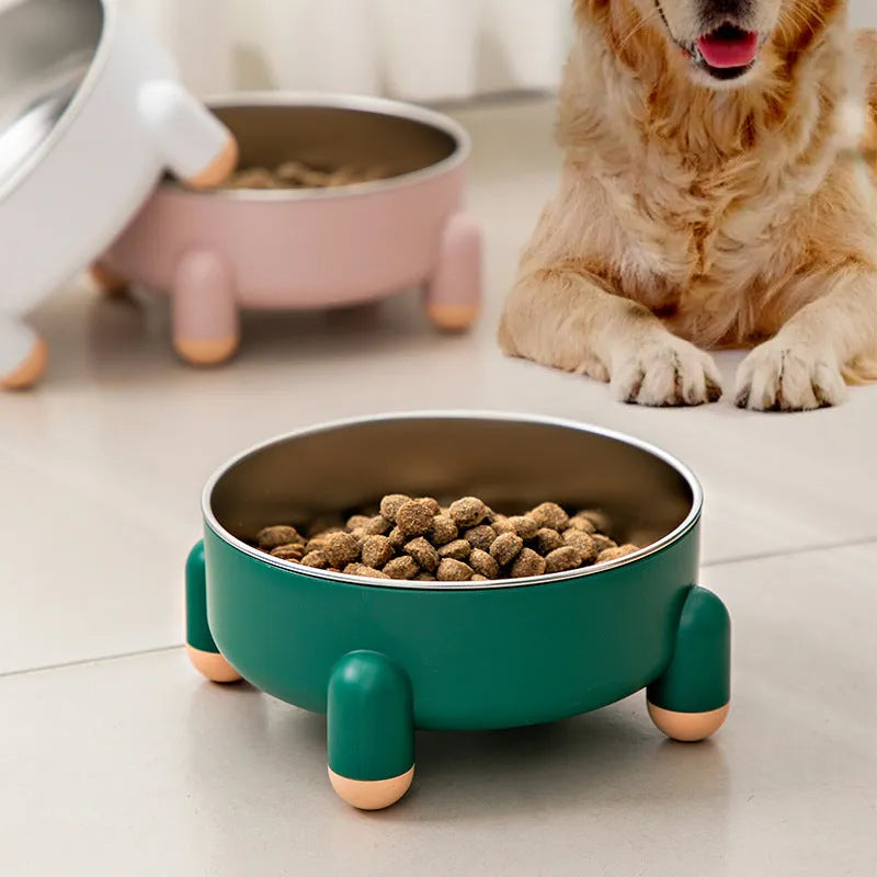 Green stainless steel pet bowl with non-slip base and high foot on a wooden floor.
