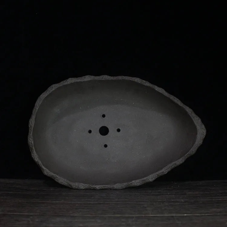 Handmade purple clay flower pot showing natural texture and drainage hole, available in five styles and three sizes