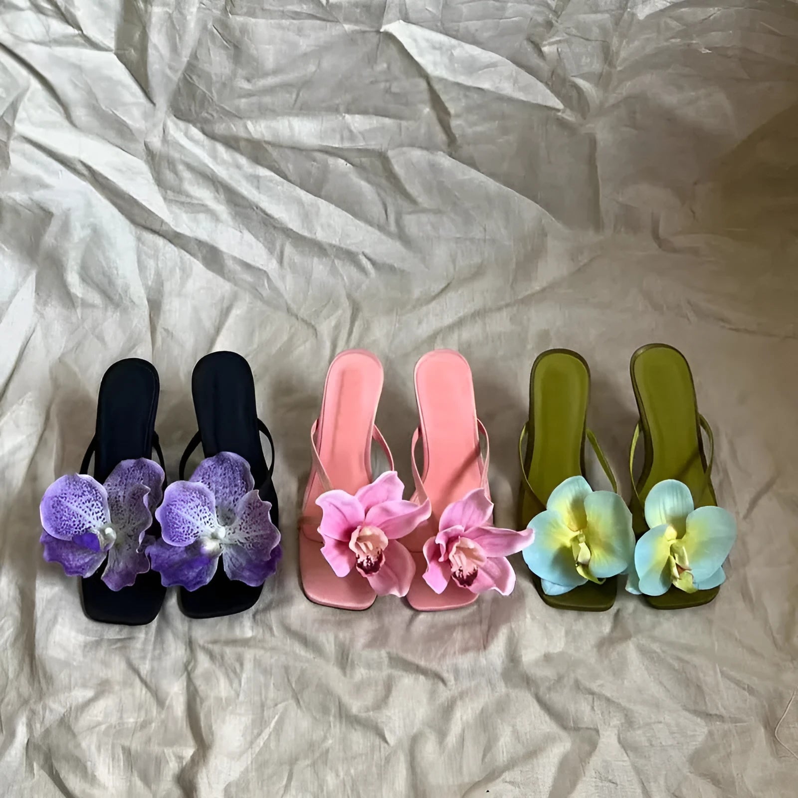 Pink women's high heel sandals with artificial white phalaenopsis flowers on the satin upper
