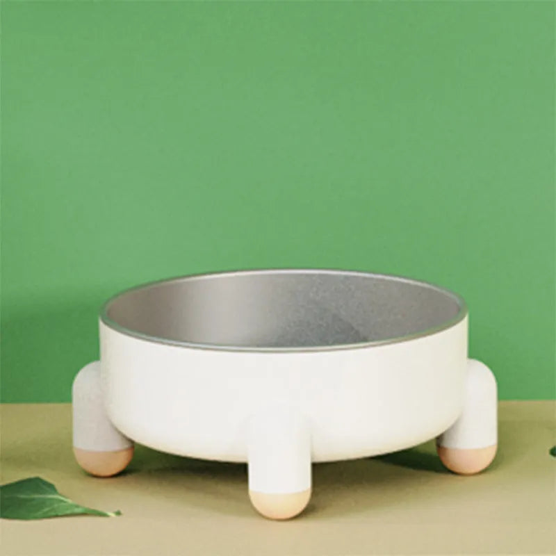 Green stainless steel pet bowl with non-slip base and high foot on a wooden floor.