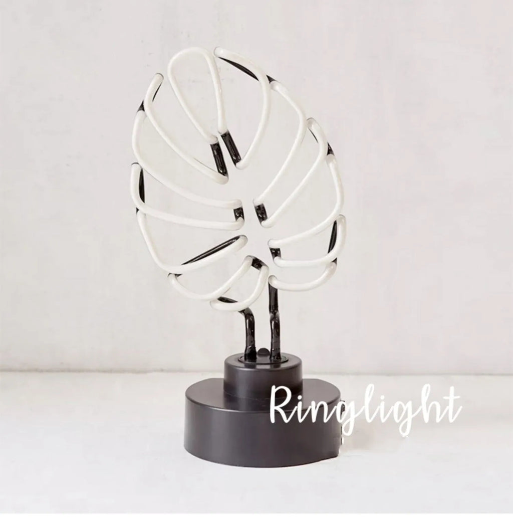 White bamboo-shaped desktop lamp with green light, USB cable, and minimalist design on wooden desk
