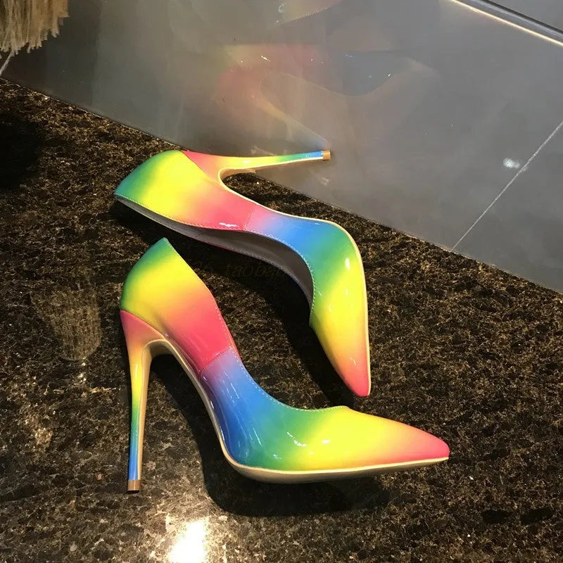 Rainbow coloured patent leather women's high heel shoe with thin stiletto heel on a white background.