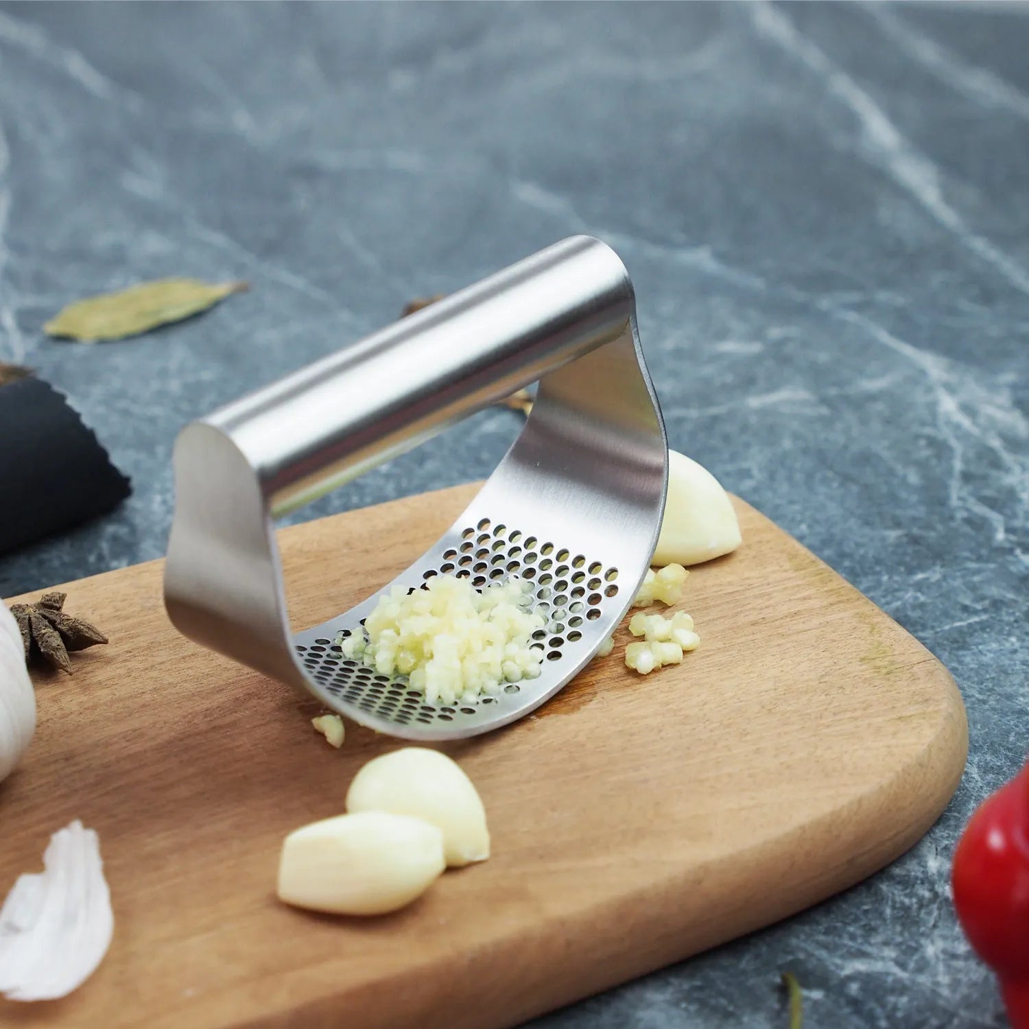 Stainless steel kitchen tool set including an onion fork and a garlic press on a kitchen counter.