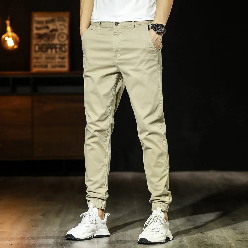 Men's cotton tapered casual trousers with ankle-tied hem, mid waist and zipper fly in khaki, black, coffee army or medium grey.