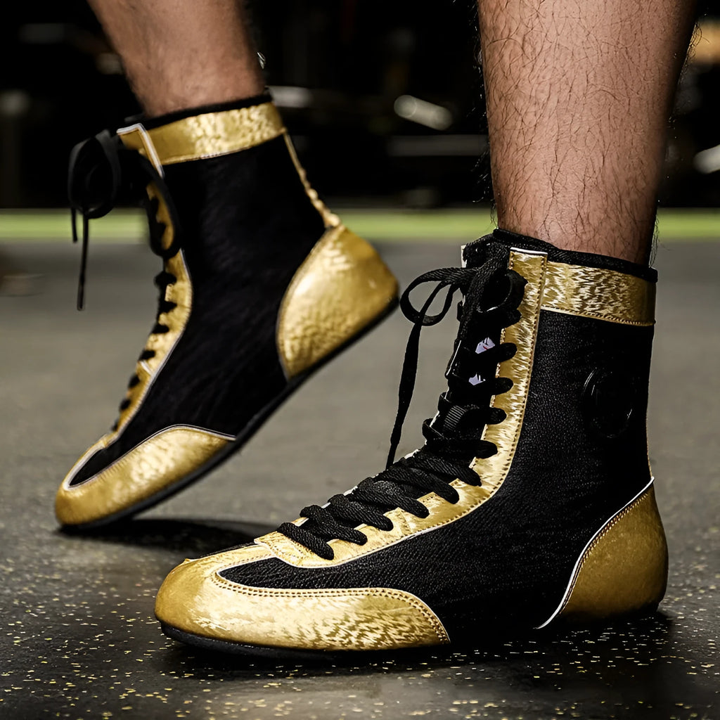 Professional black and gold mesh boxing shoes with leather upper and rubber sole.
