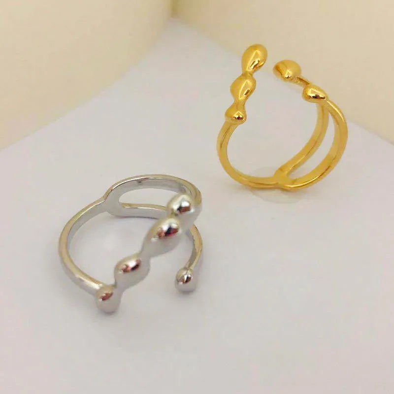 Adjustable brass fashion ring with spherical design in gold finish on hand