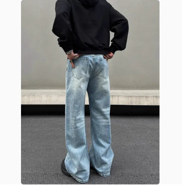 Men's blue straight-leg jeans with whisker wash detailing and a flared leg.