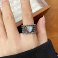 Retro wide-faced heart-shaped ring with adjustable opening in white copper plated silver, showing love-themed details