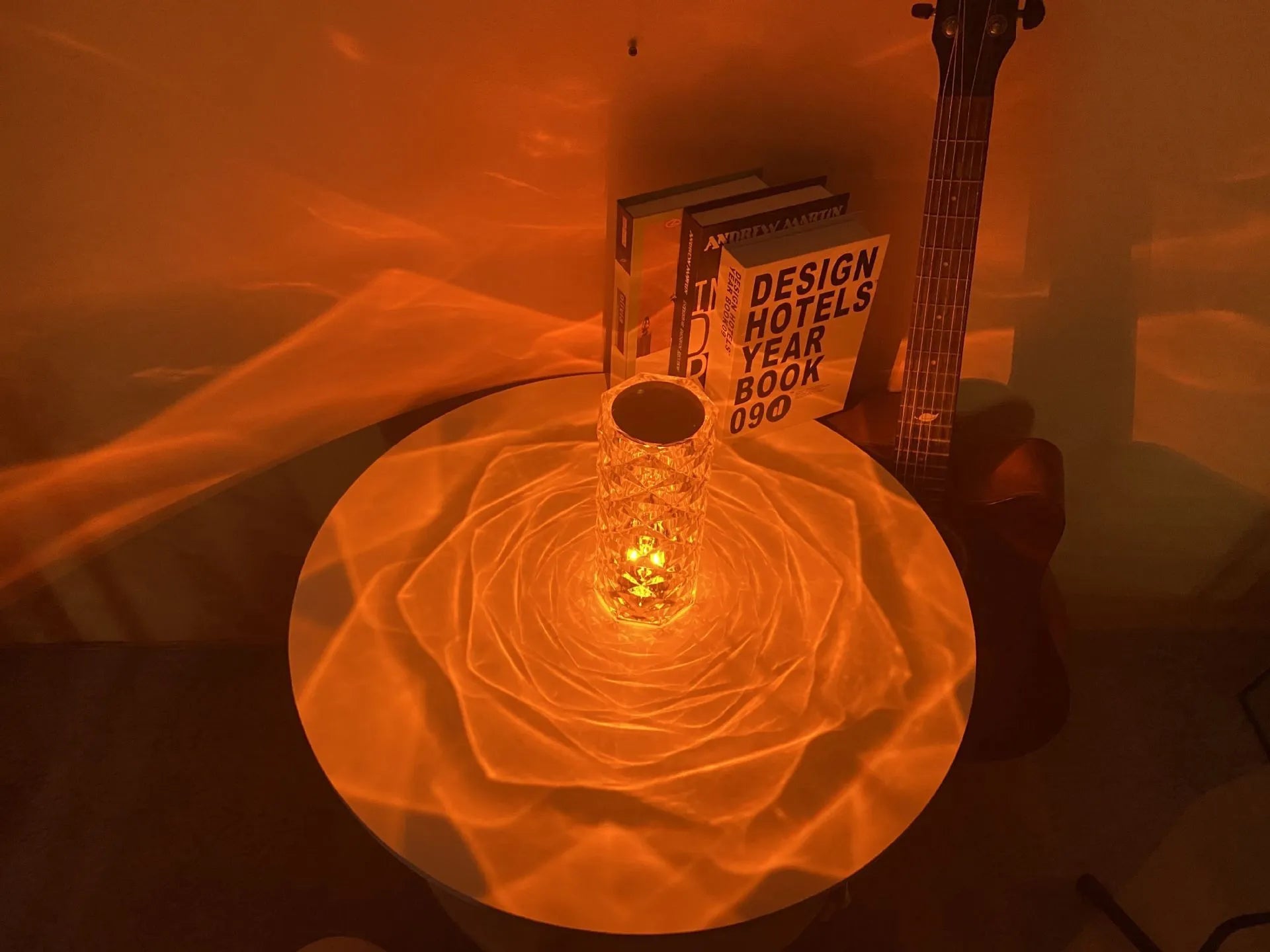 Clear acrylic rose-shaped LED table lamp with touch controls on a wooden surface.