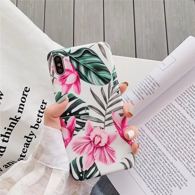 Pink flower design TPU phone case for iPhone on a table.