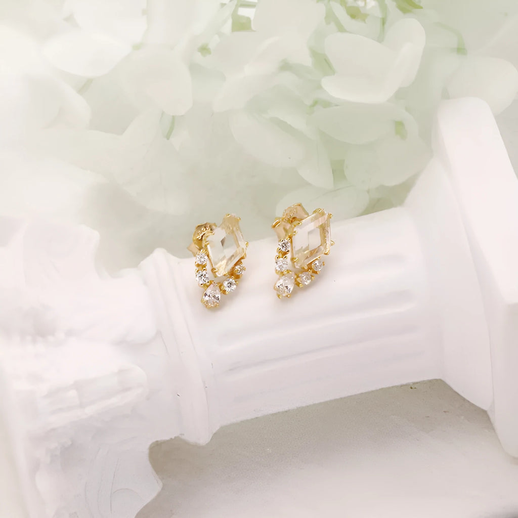 Geometric silver earrings with sweet white crystal studs showing structured design